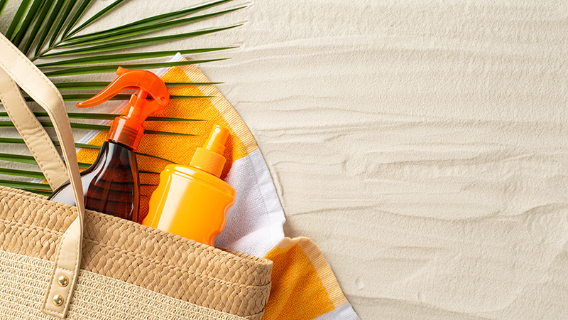 borsa da spiaggia con creme solari e spray
